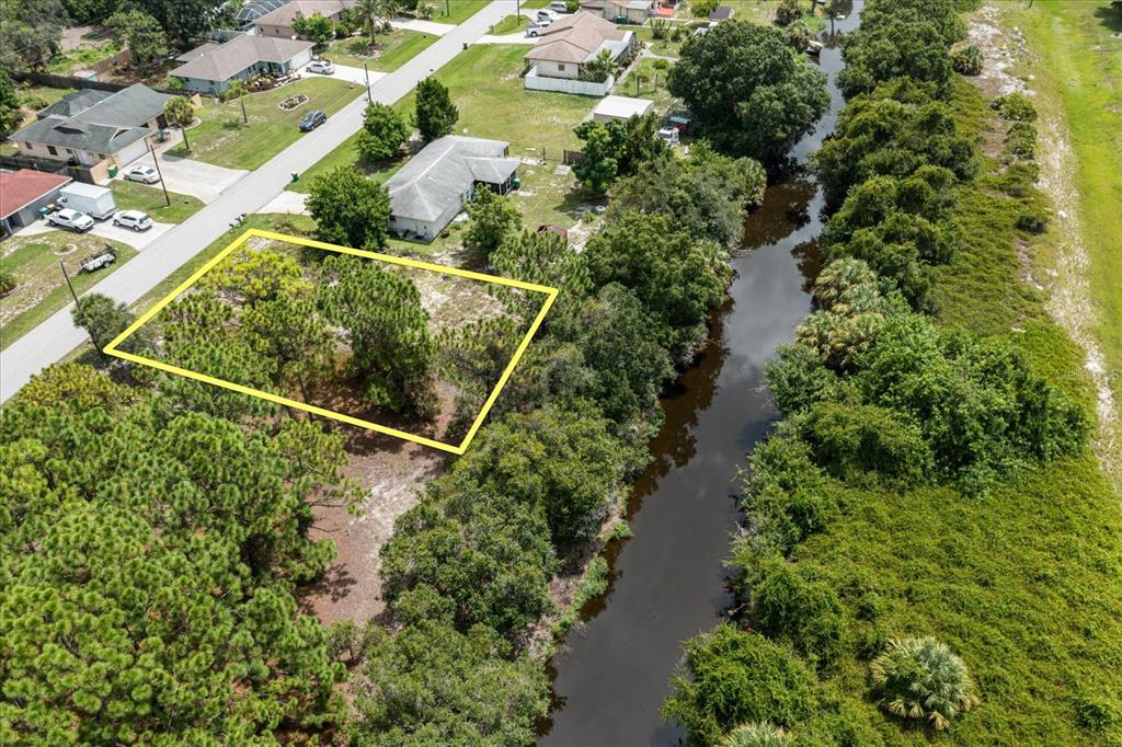 an aerial view of residential house with outdoor space and trees all around