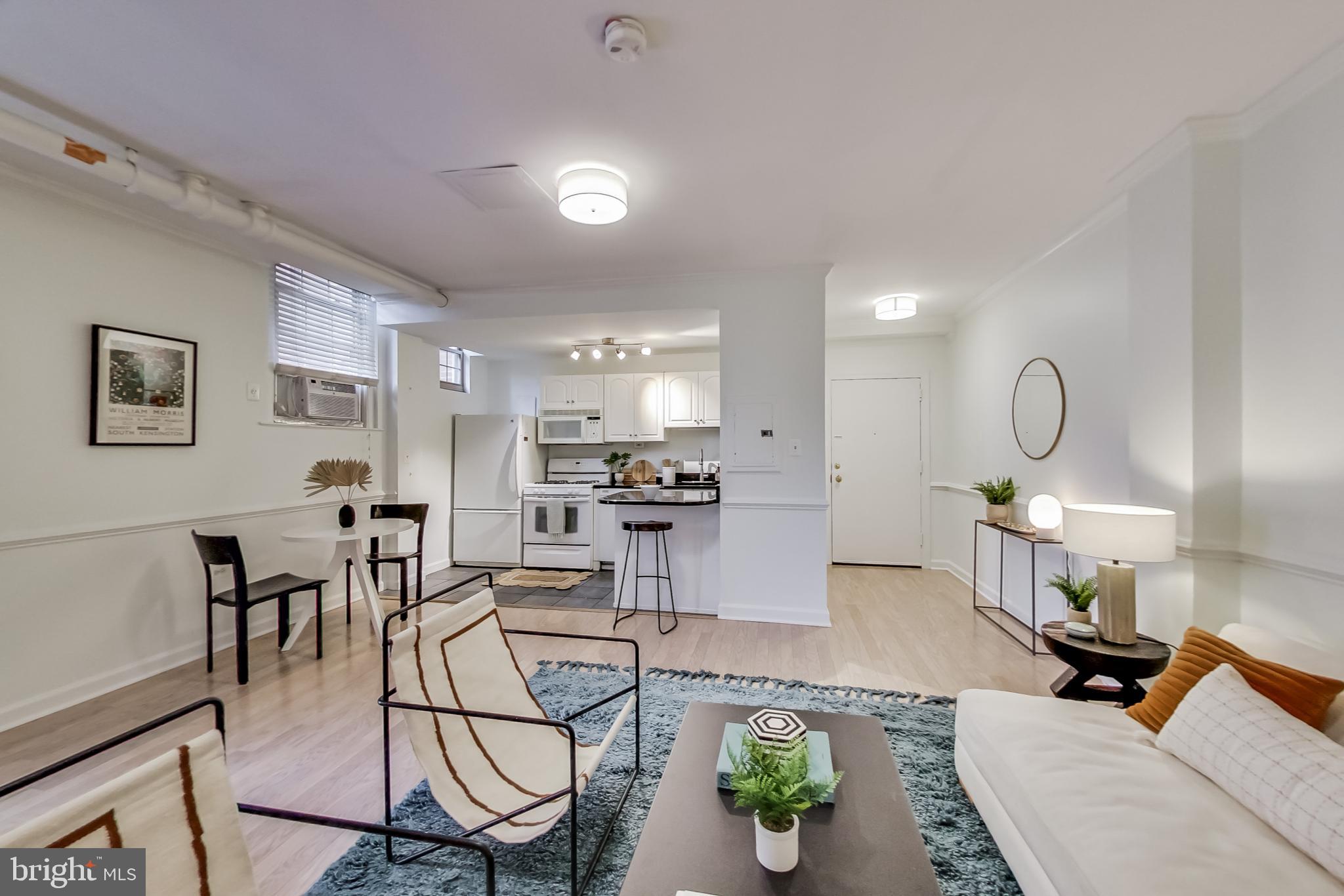 a living room with furniture a rug and white walls