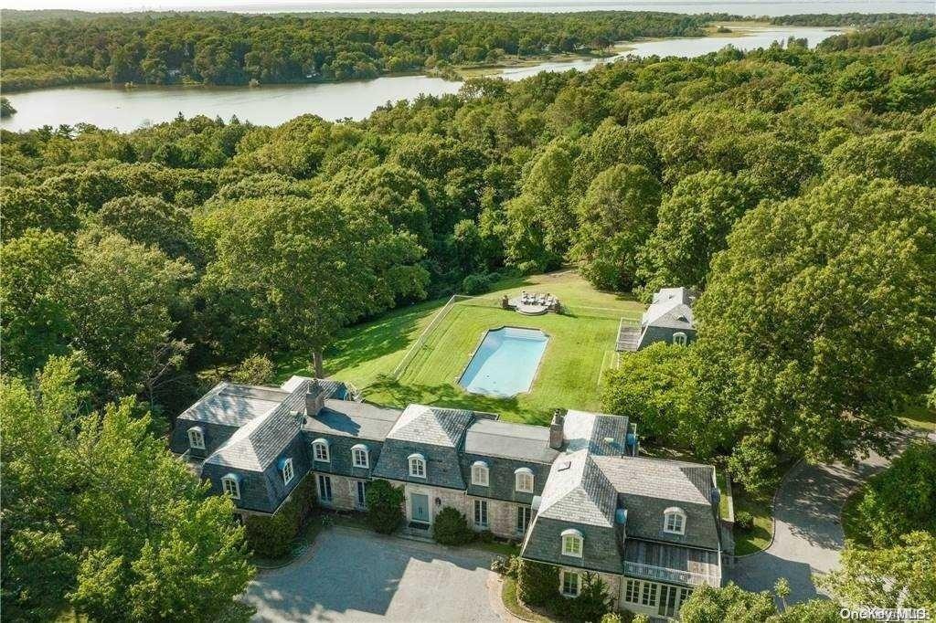 an aerial view of a house with a yard and lake view