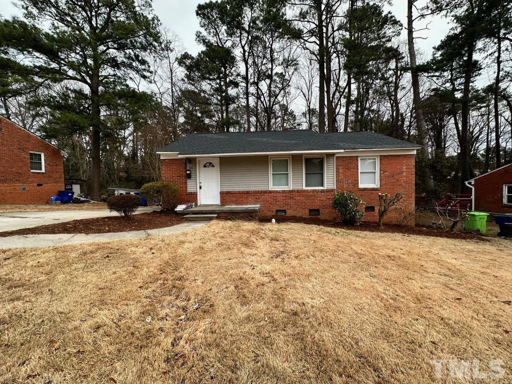 a front view of house with yard and trees around