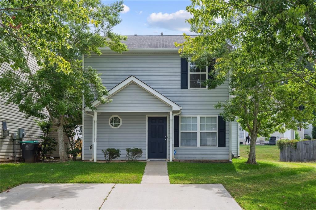 a front view of a house with a garden and yard