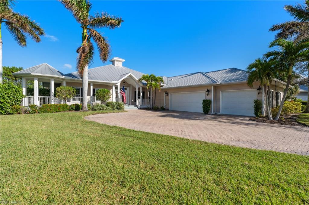 Ranch-style house featuring a garage, a front lawn, and a porch