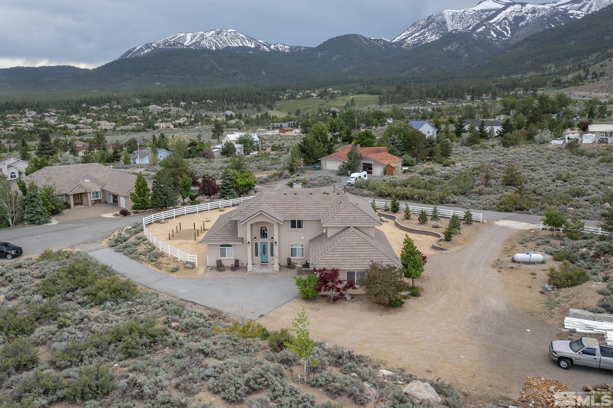 an aerial view of a house with a garden and mountain view