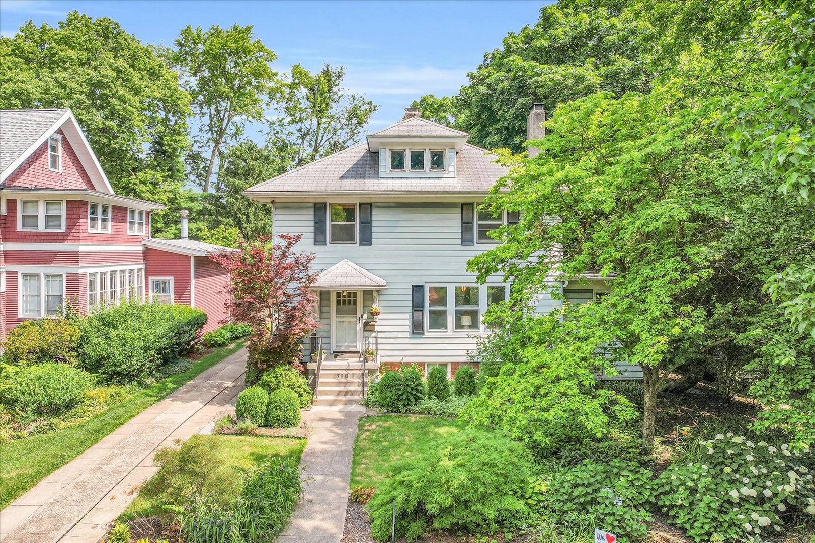 a front view of a house with a yard and potted plants