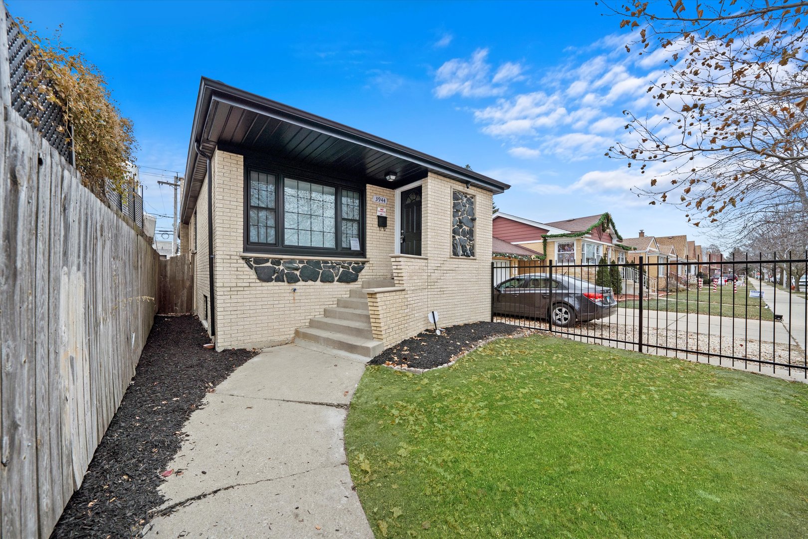 a view of a house with a small yard and wooden fence