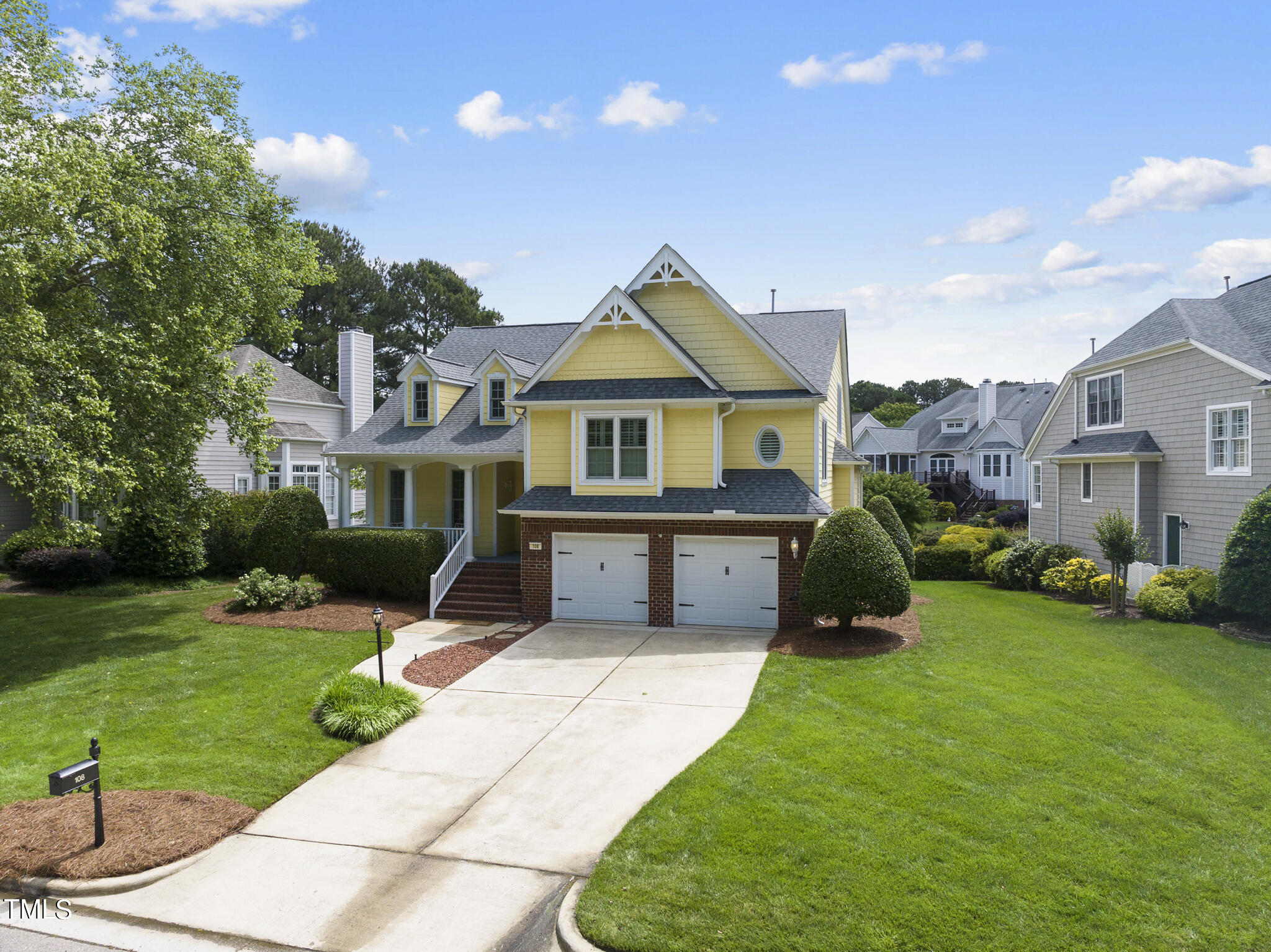 a front view of a house with a yard and a garden