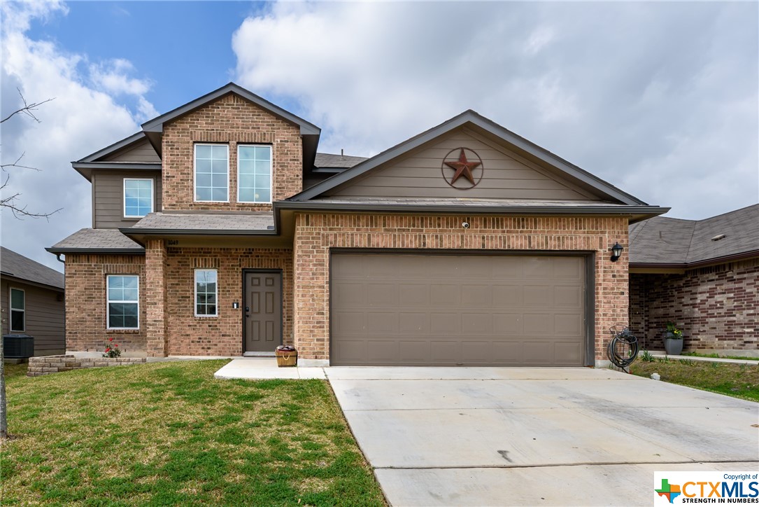 a front view of a house with a yard and garage