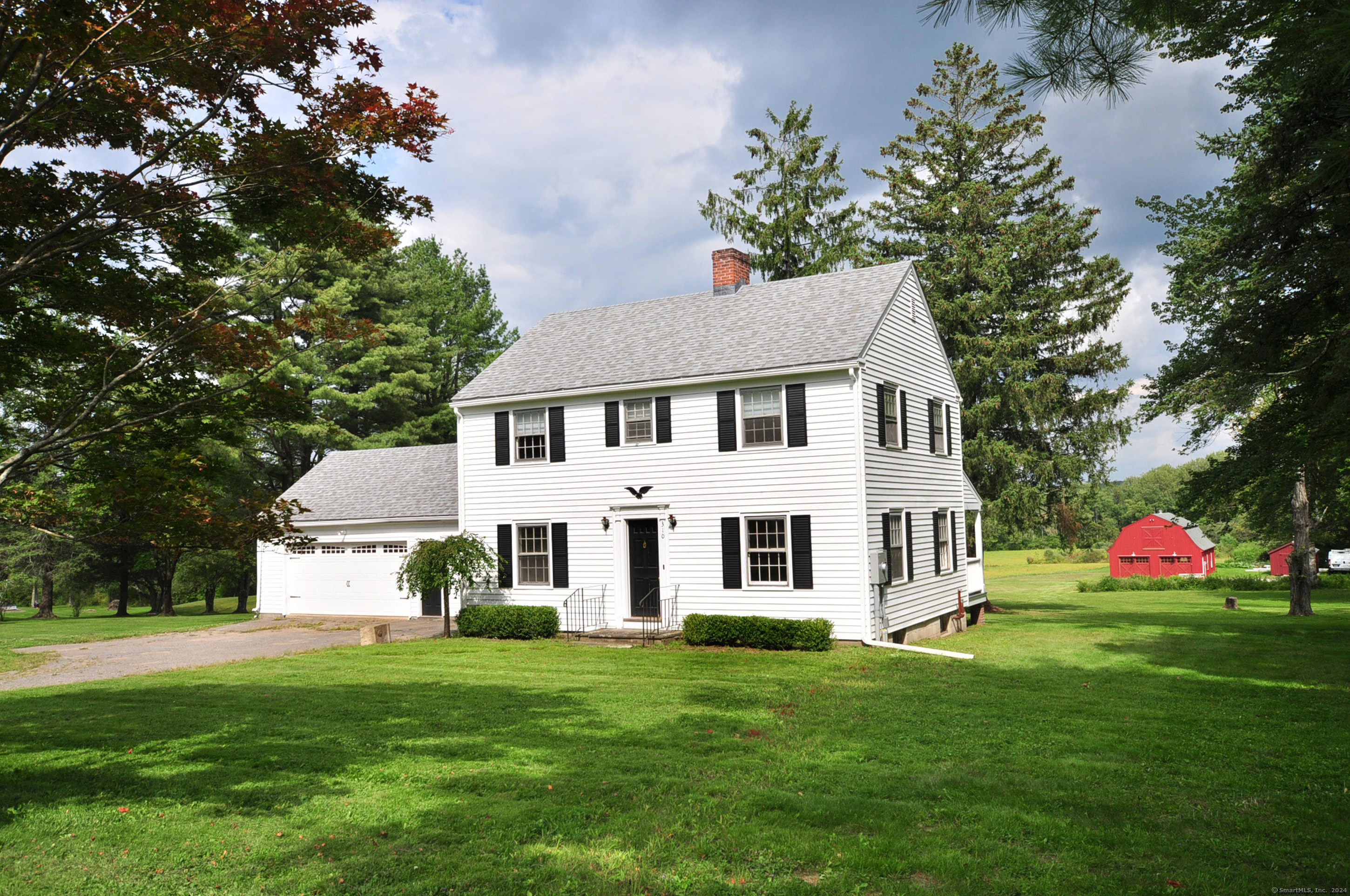 a front view of a house with a yard table and trees