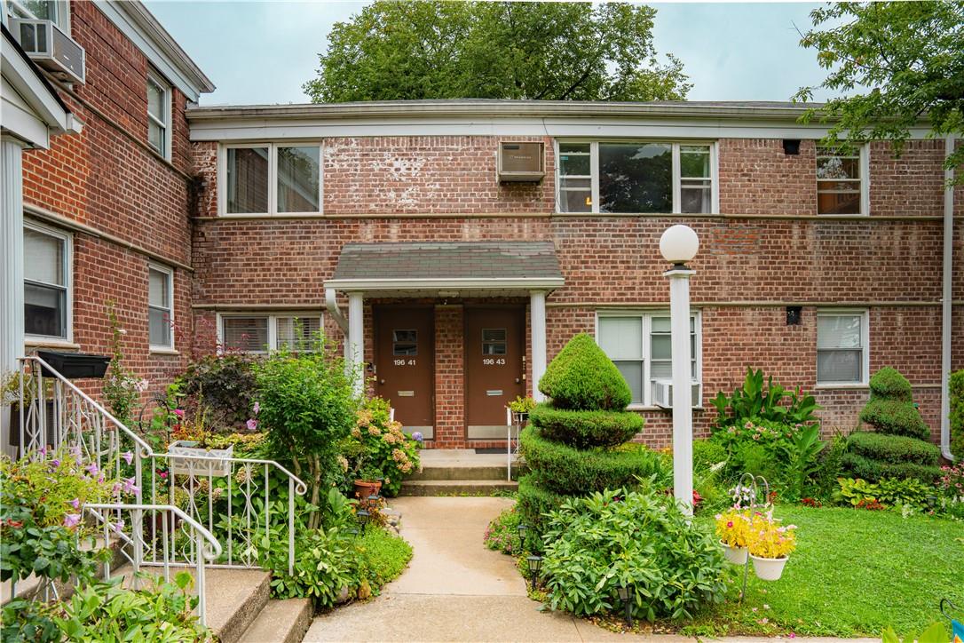 a front view of a house with a yard and potted plants