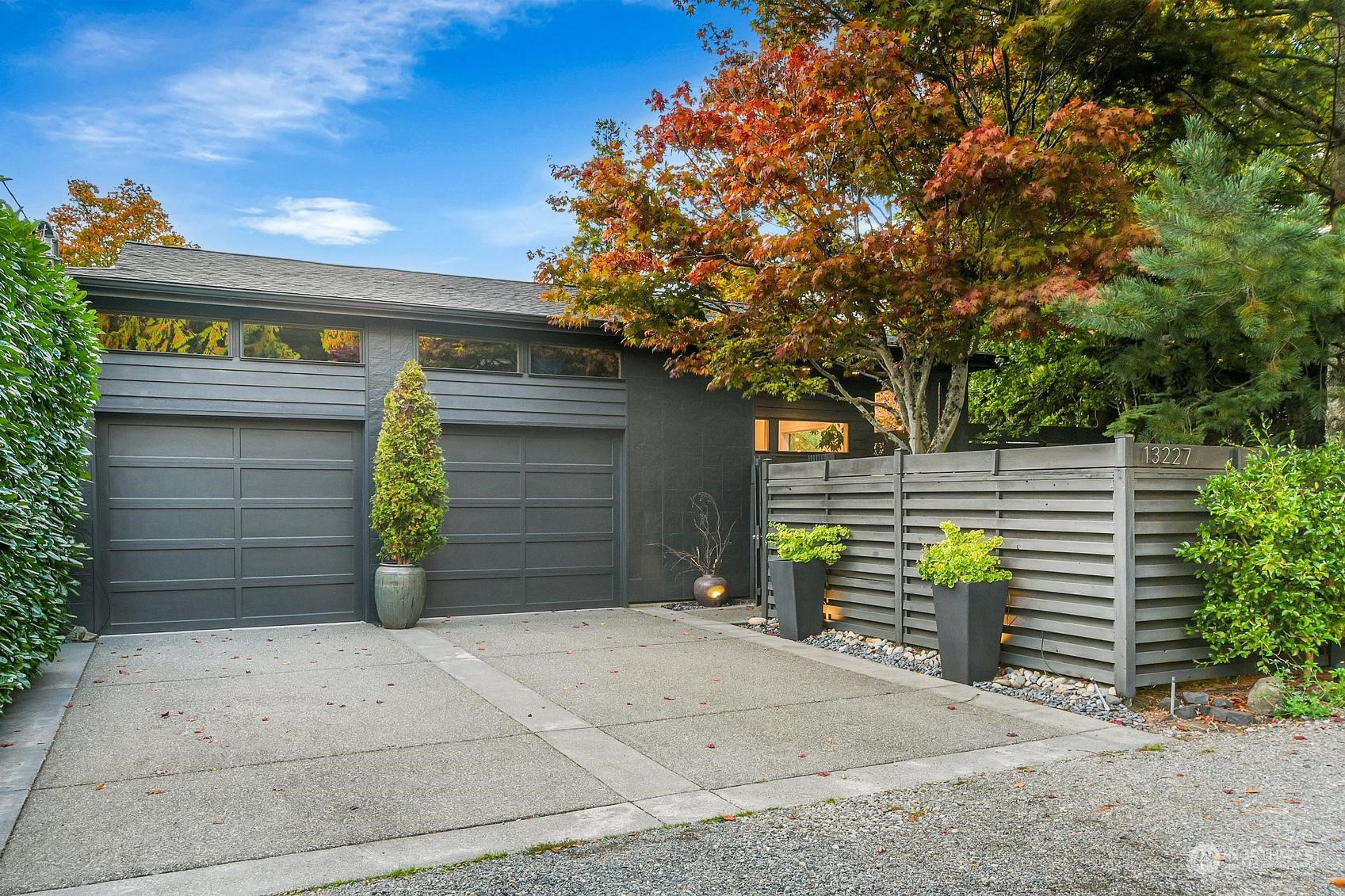 a view of a house with potted plants and a garage