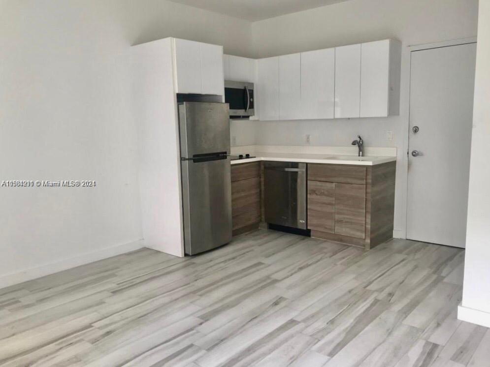 a kitchen with wooden cabinets and a refrigerator