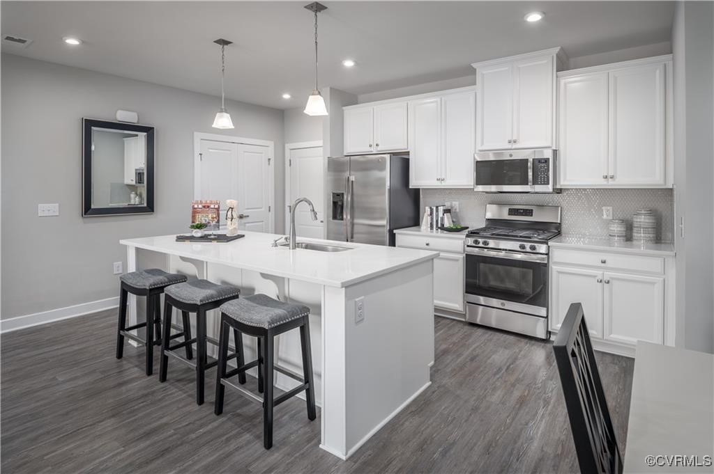 a kitchen with a dining table chairs stainless steel appliances and cabinets