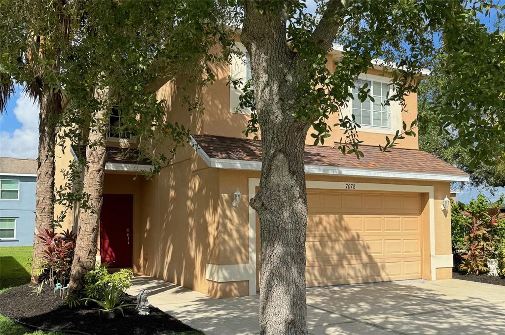 a front view of a house with a tree