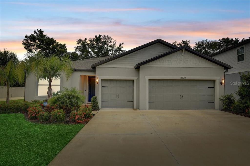 a front view of a house with a yard and garage