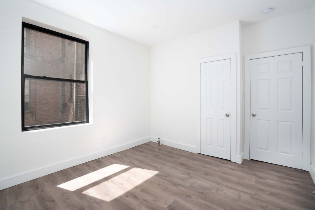 an empty room with wooden floor and a window