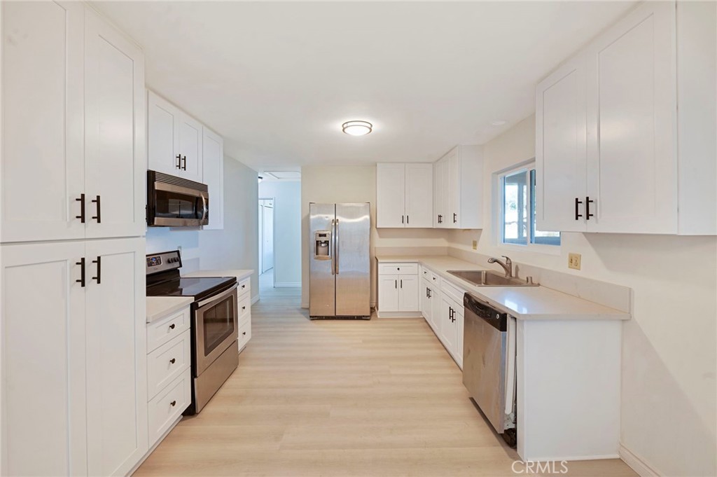 a kitchen with stainless steel appliances a stove sink microwave and refrigerator