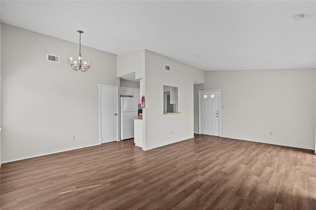 a view of a room with wooden floor and a ceiling fan