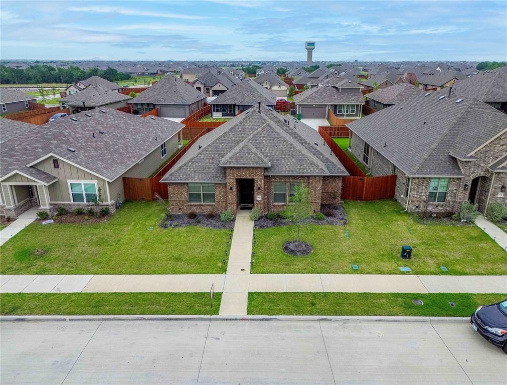 a aerial view of a house with a big yard and potted plants