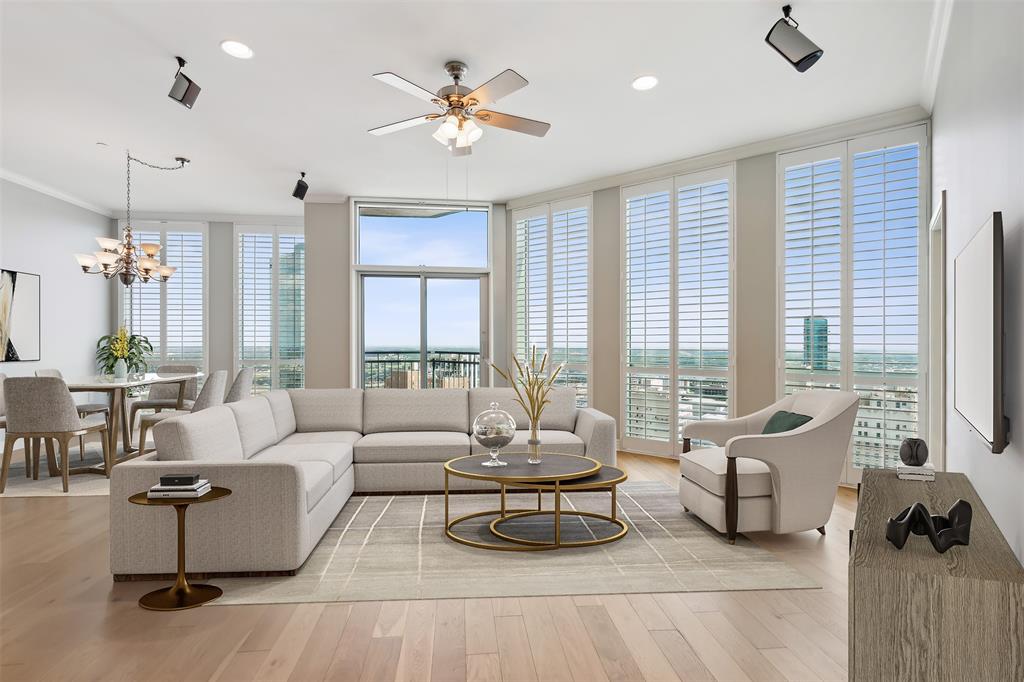 a living room with furniture and floor to ceiling windows