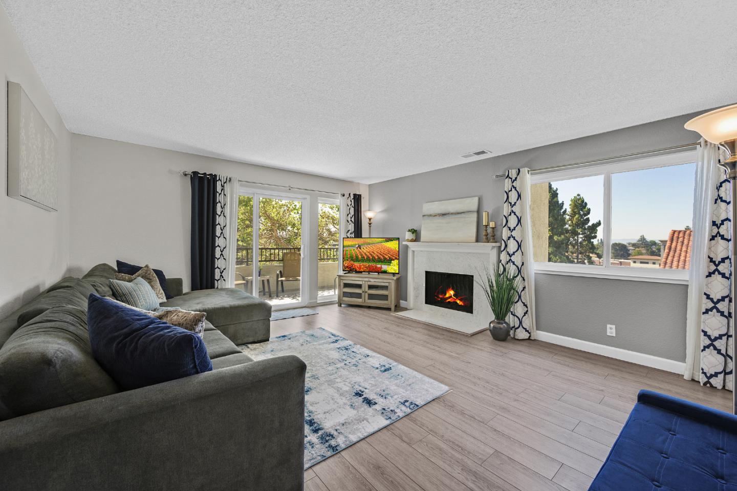 a living room with furniture a fireplace and a large window