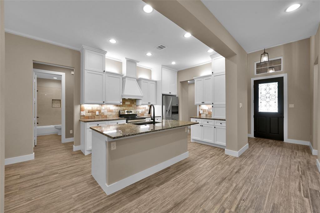 a kitchen with stainless steel appliances granite countertop a stove and a refrigerator