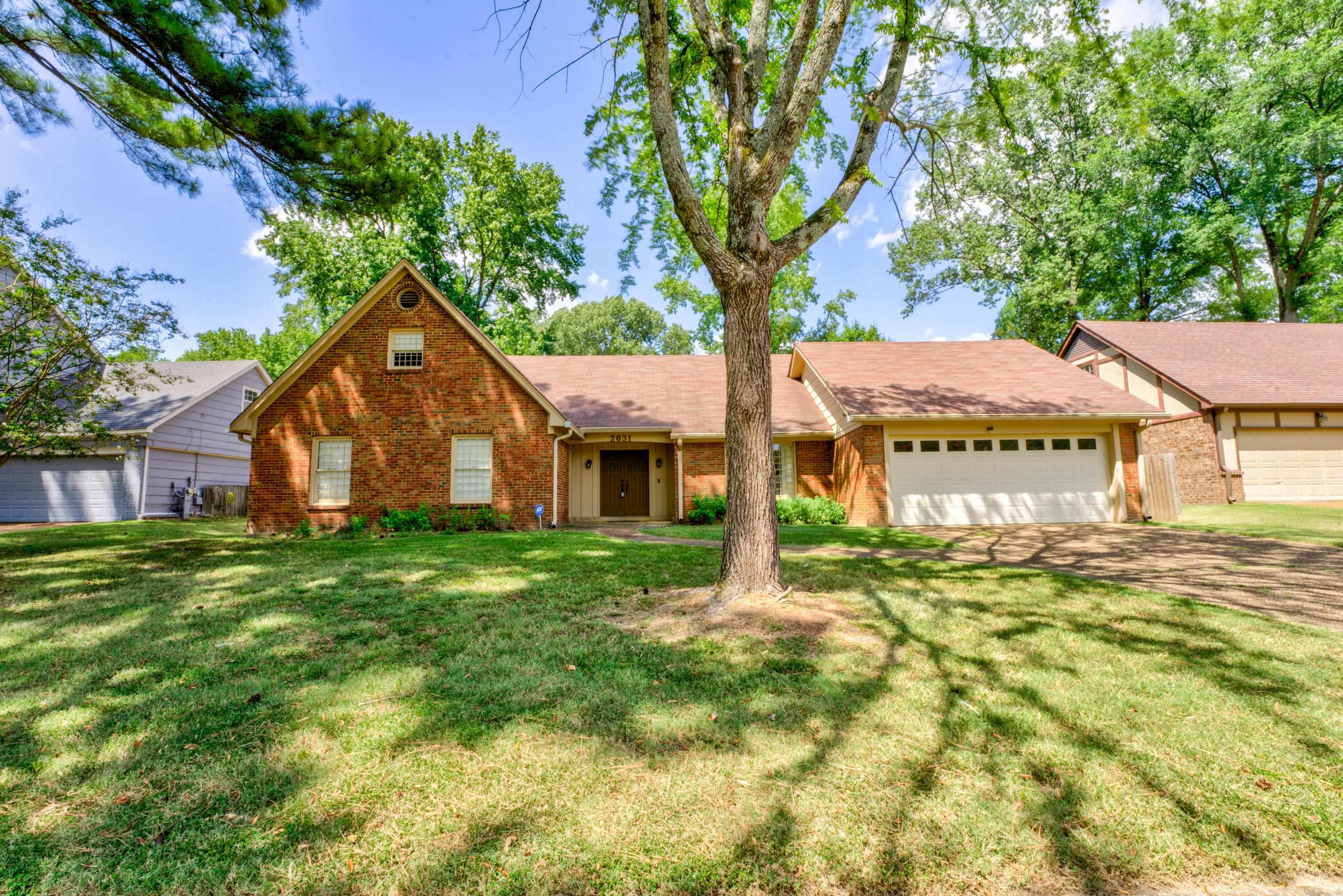 View of front of property with a front yard and a garage