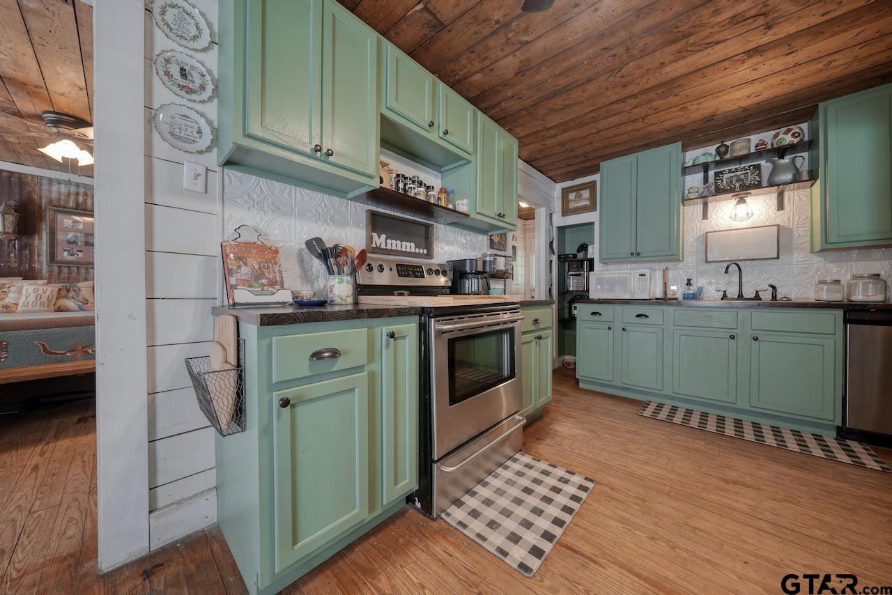 a kitchen with stainless steel appliances granite countertop a sink a stove and cabinets