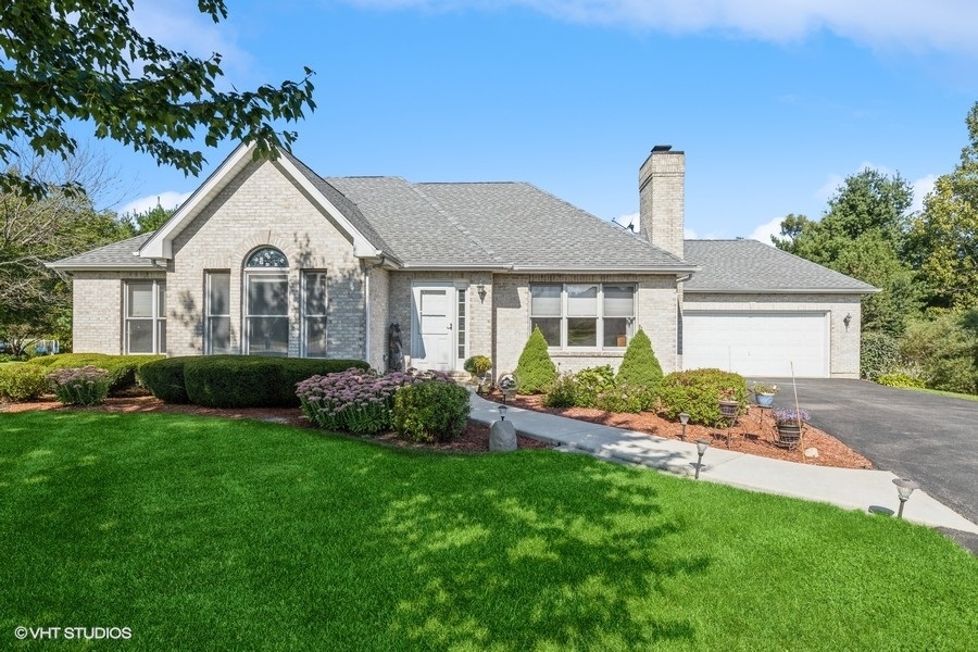 a front view of a house with a garden and plants