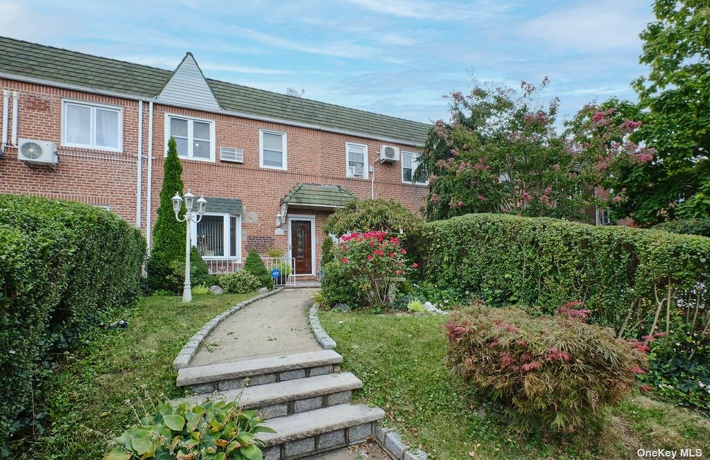 a front view of a house with a yard and trees