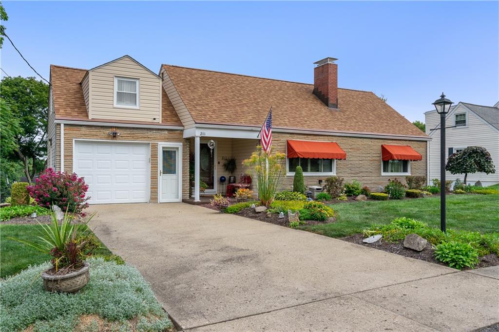 a front view of a house with a garden and plants