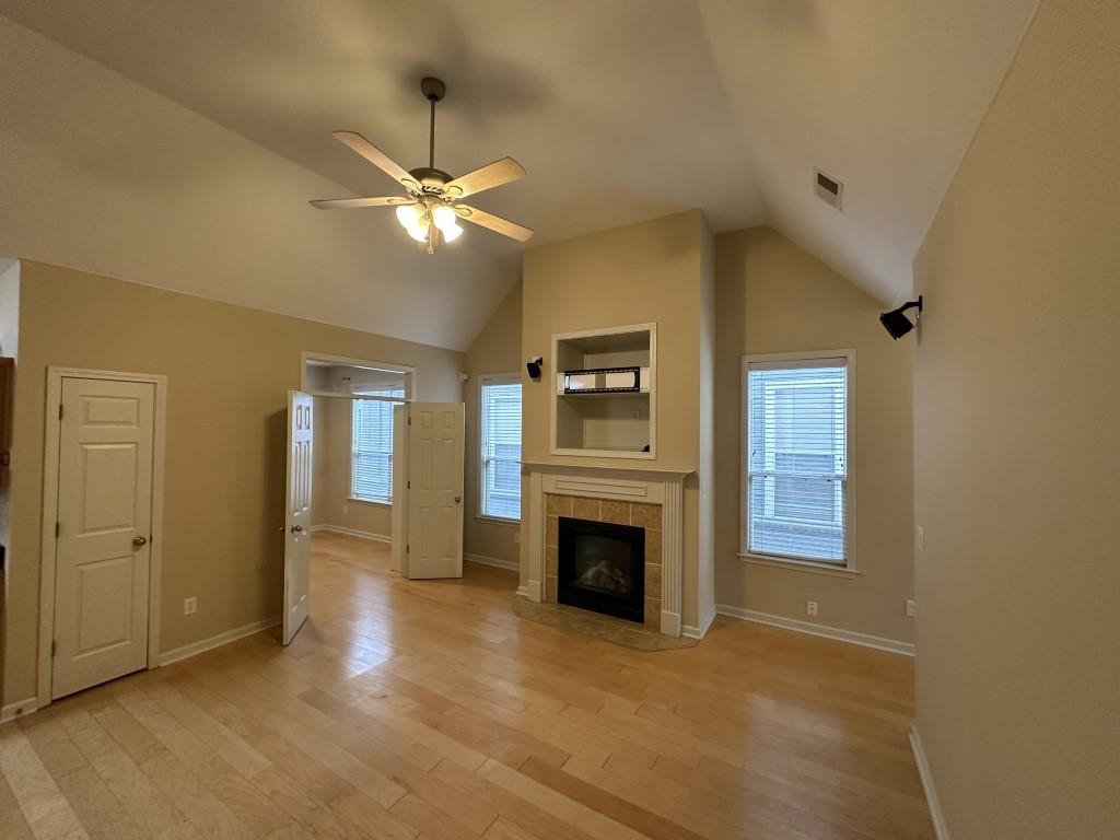 an empty room with windows and fireplace