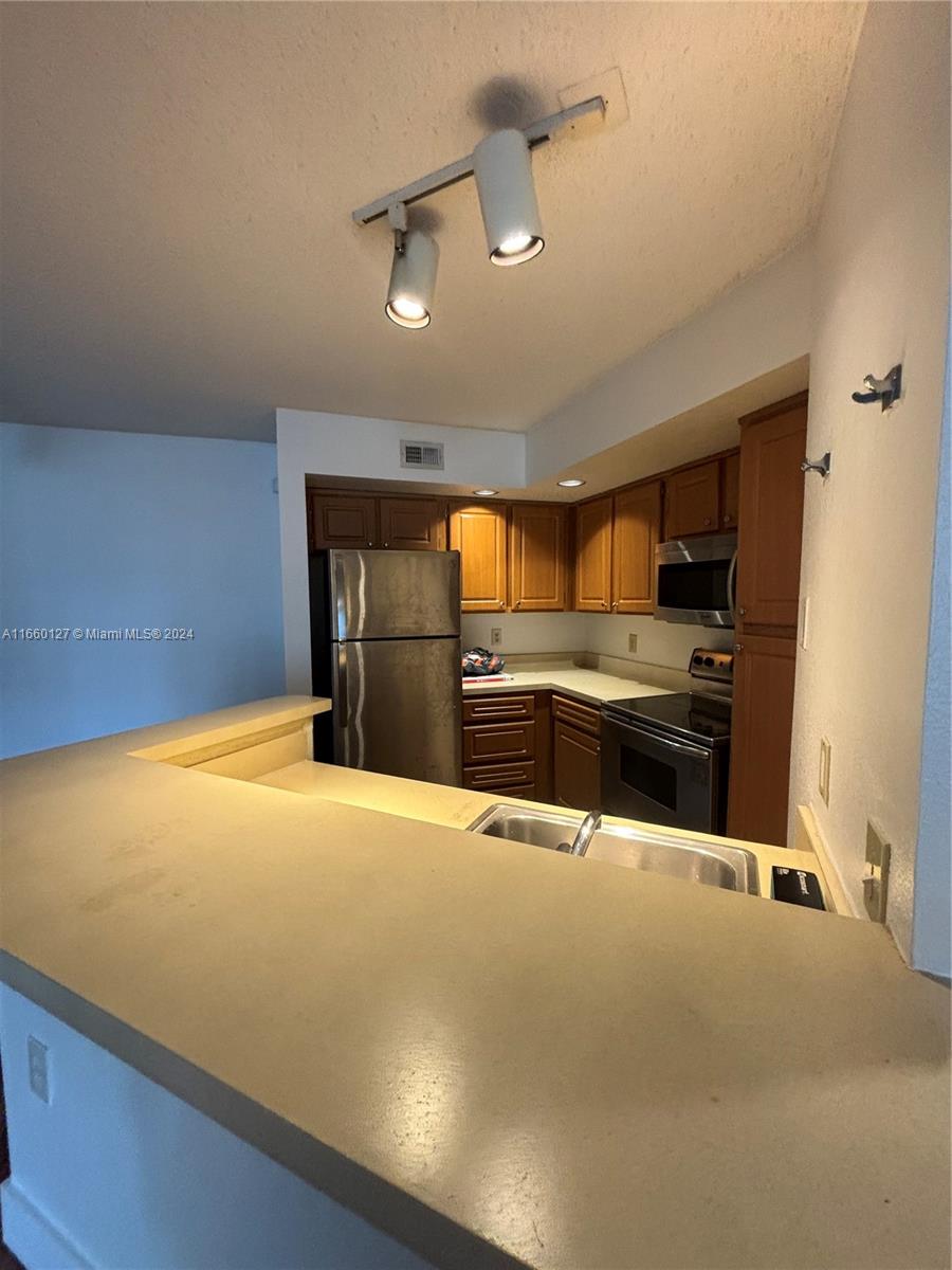 a kitchen with stainless steel appliances a refrigerator and a stove top oven