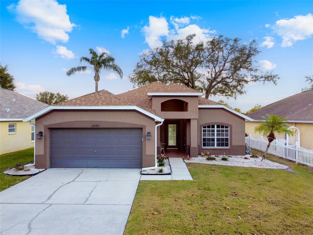 a front view of a house with yard garage and outdoor seating