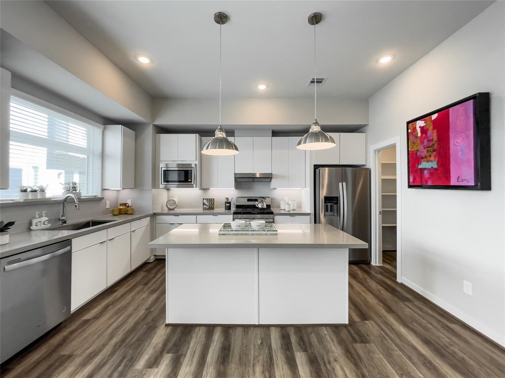 a large kitchen with stainless steel appliances granite countertop a lot of counter space and a sink