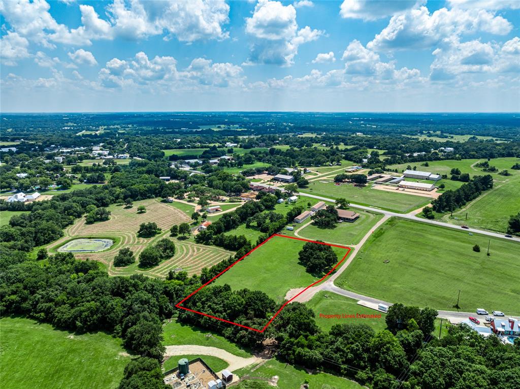 an aerial view of residential houses with outdoor space and trees