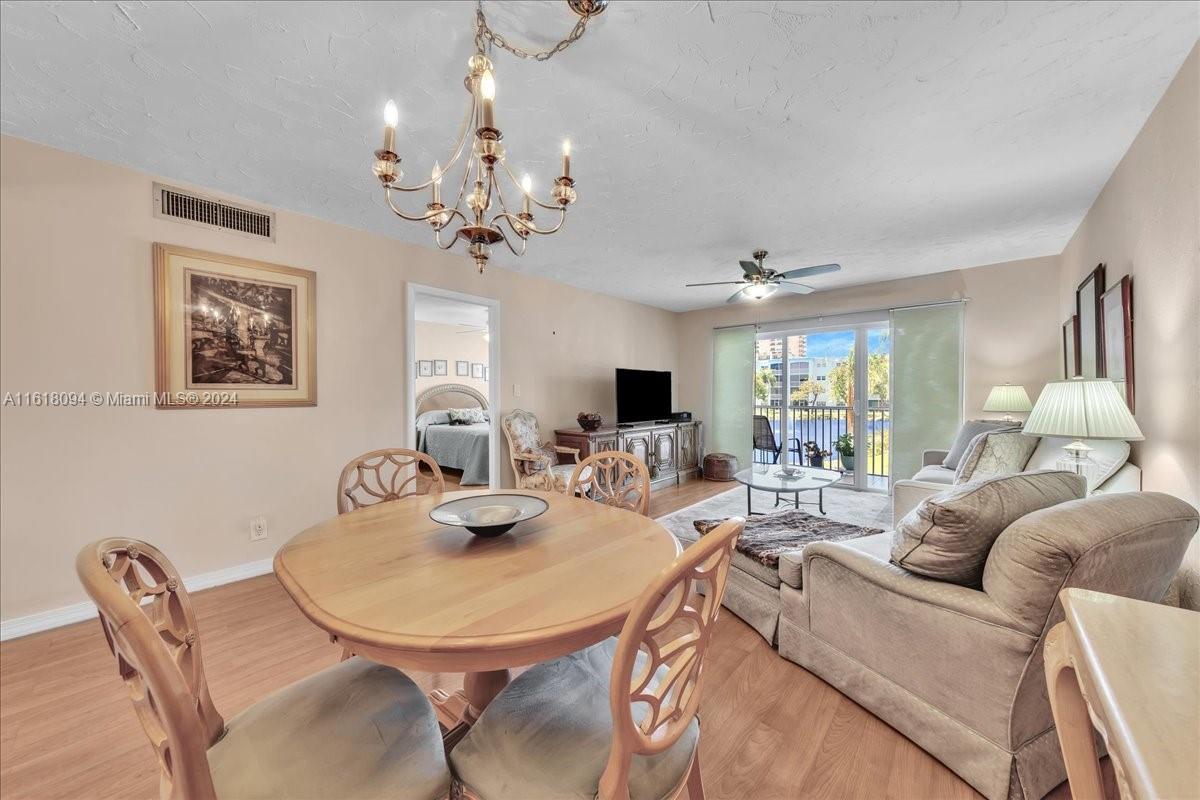 a living room with furniture a chandelier and a dining room