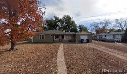 a front view of a house with a garden and trees