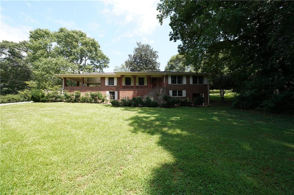 a view of a house with a yard and sitting area