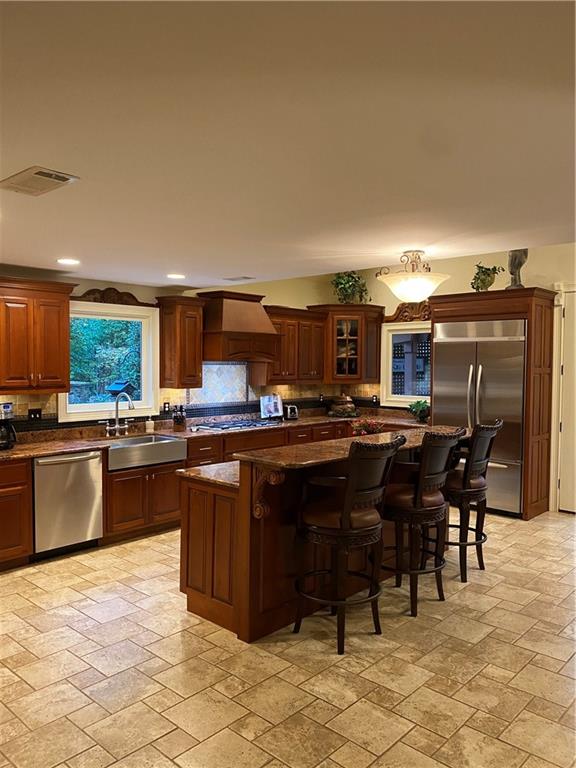 a kitchen with lots of wooden cabinets a table and chairs