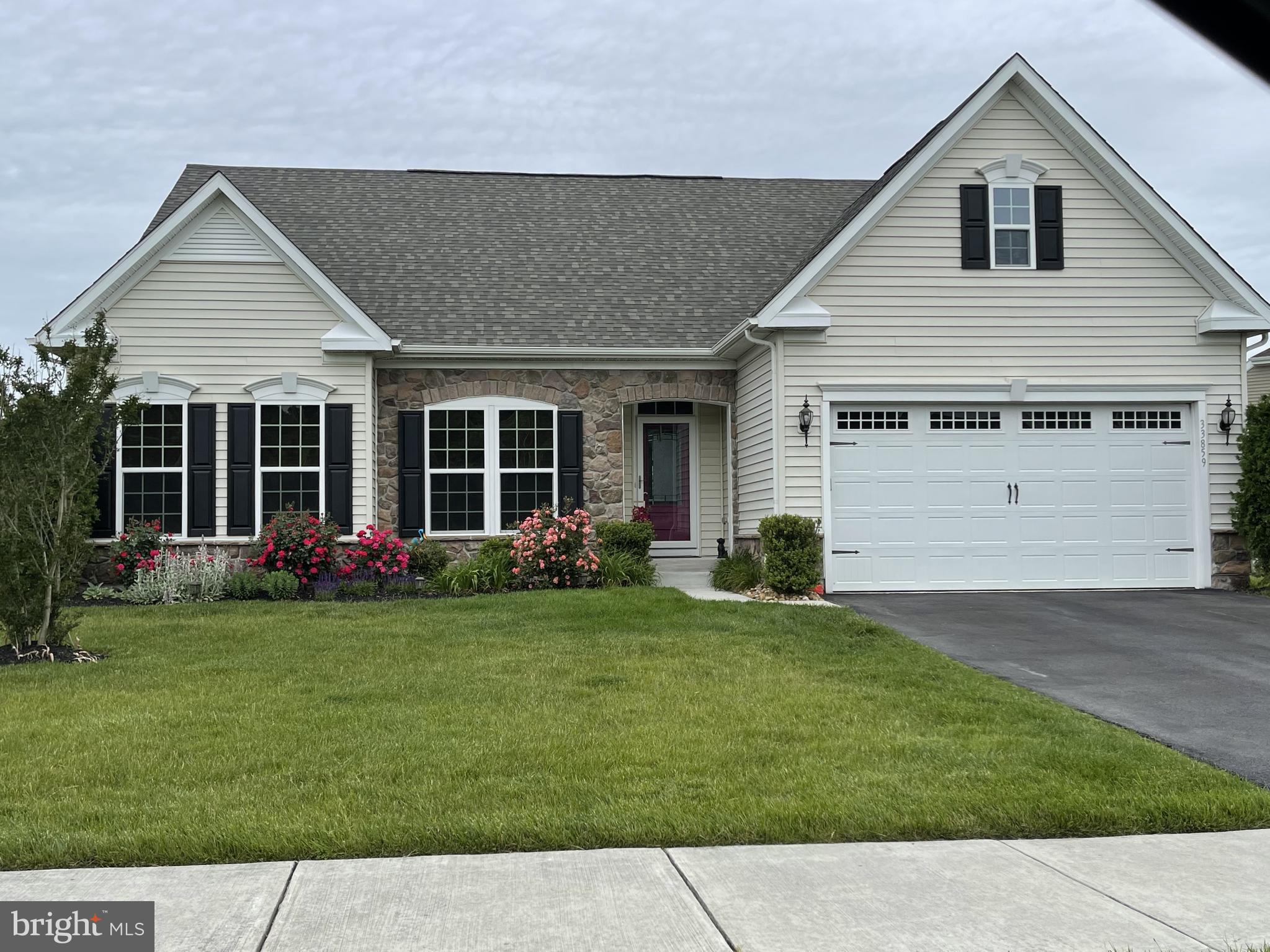 a front view of a house with a garden and yard