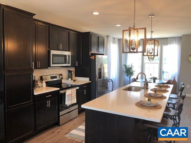 a kitchen with stainless steel appliances a sink stove and refrigerator