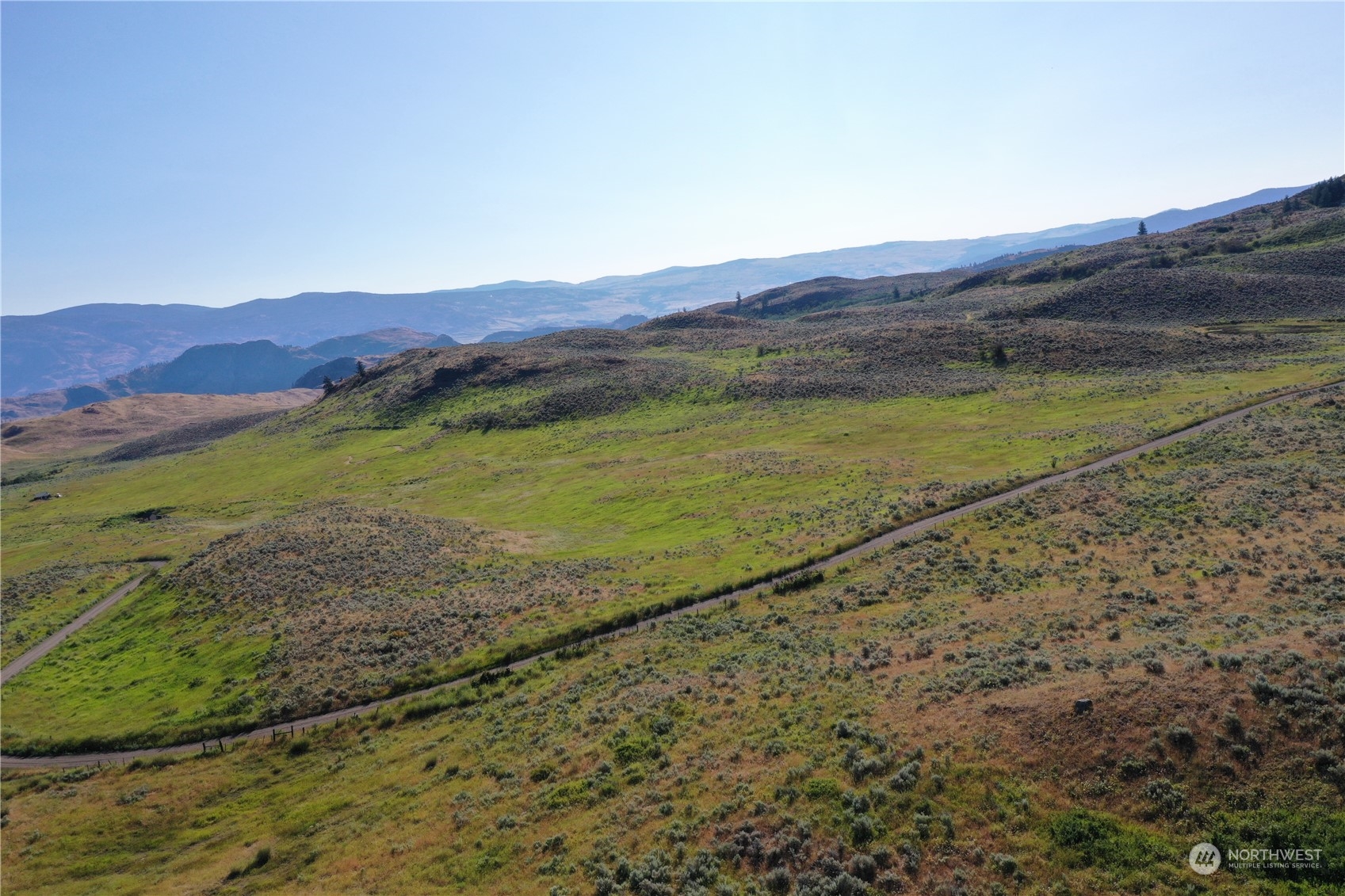 a view of a mountain with a field