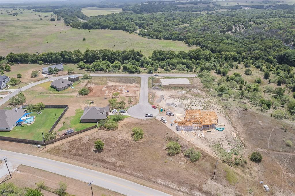 an aerial view of a house with a yard and lake view