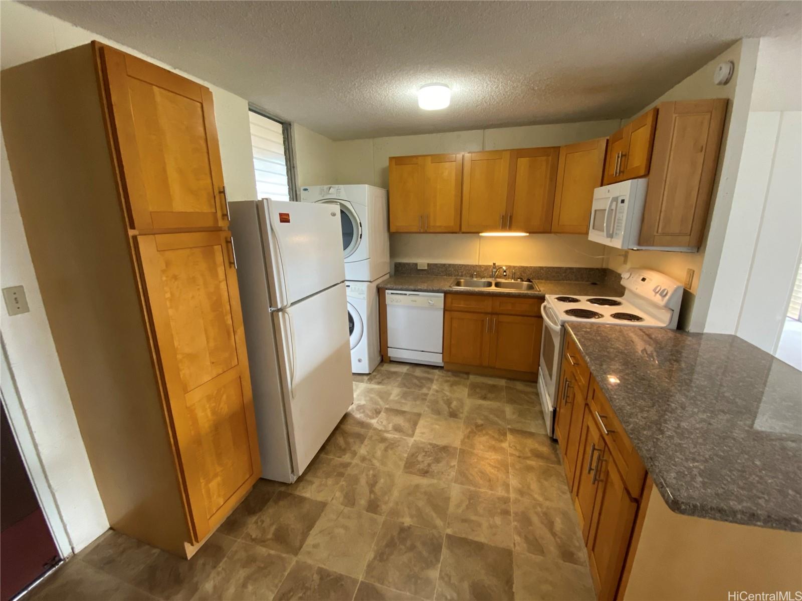 a kitchen with stainless steel appliances granite countertop a refrigerator a stove and a sink