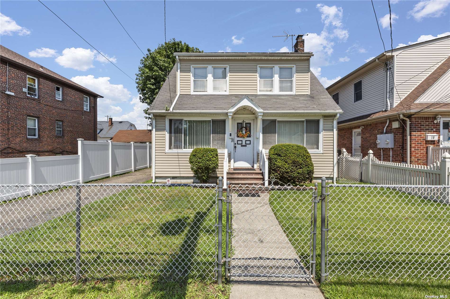 a front view of a house with a lots of windows and plants