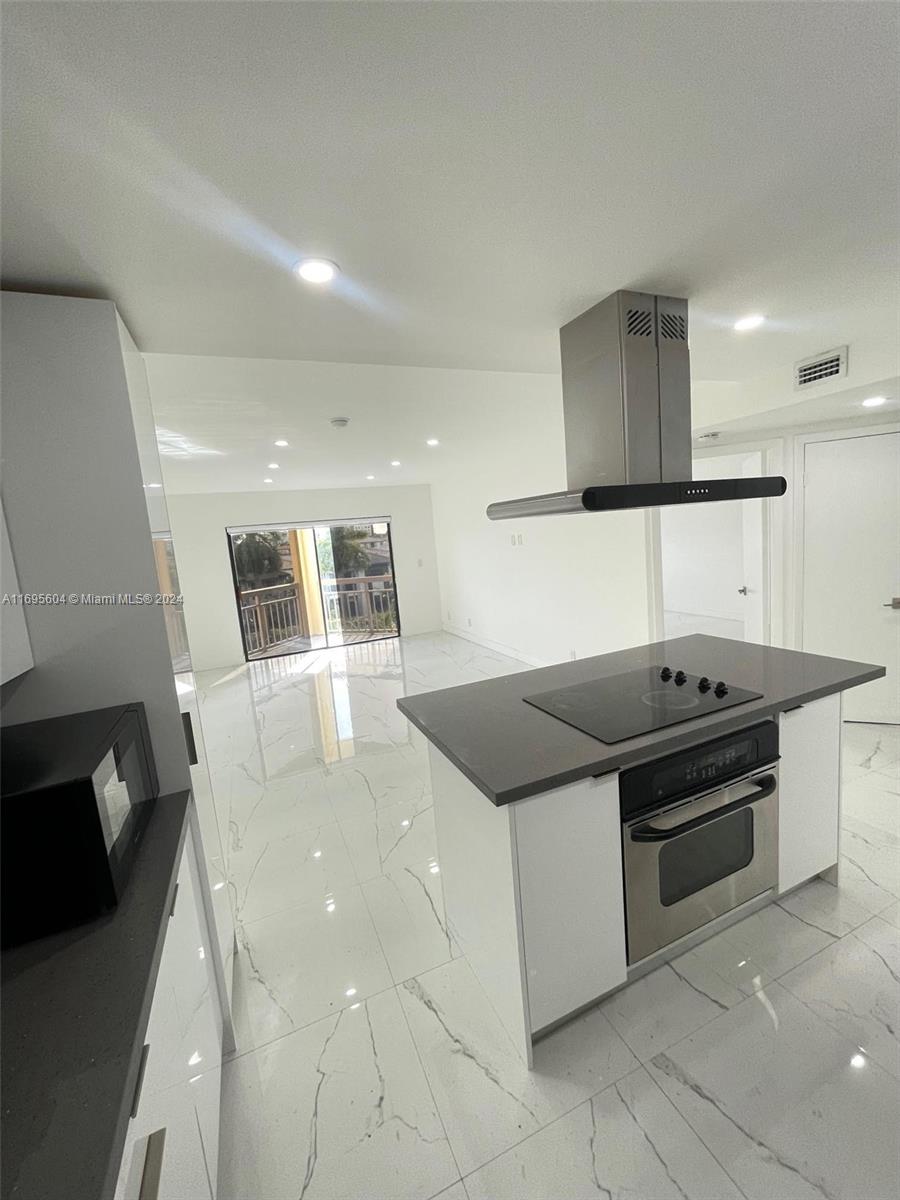 a kitchen with granite countertop a stove and a refrigerator