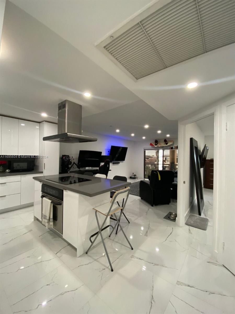 a kitchen with stainless steel appliances kitchen island granite countertop a sink and cabinets