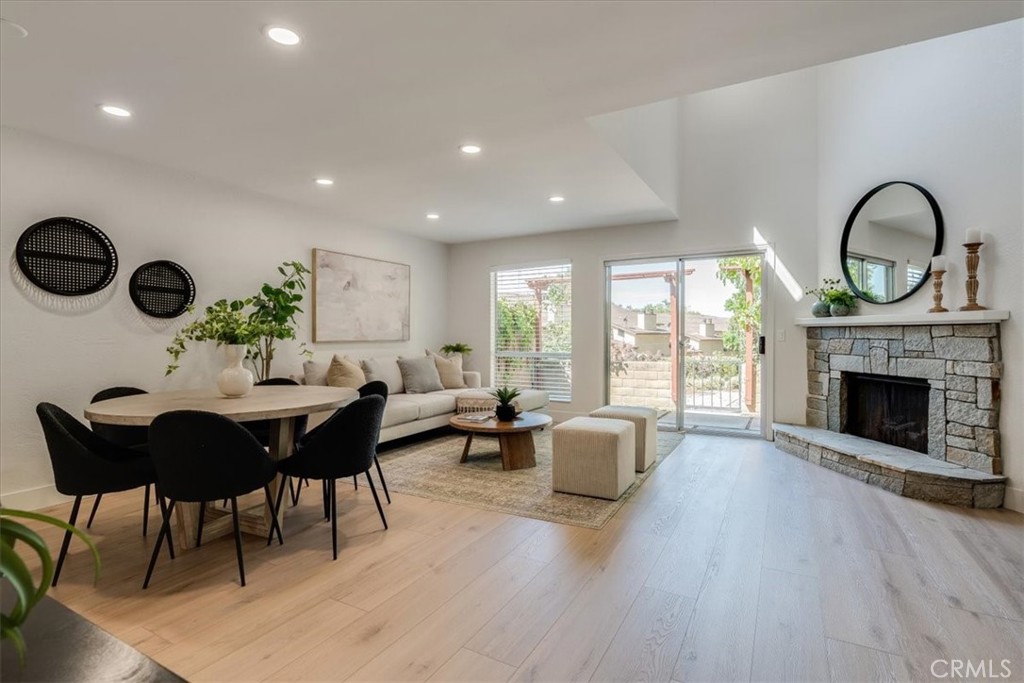 a living room with furniture a fireplace a rug and a large window