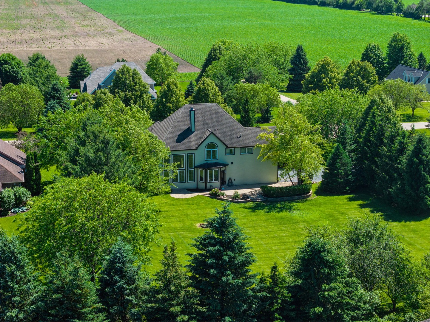 an aerial view of a house with pool big yard and large trees