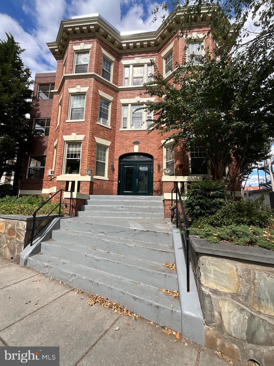 a front view of a residential apartment building with a yard